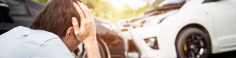 head on collision car accident victim in distress holding head