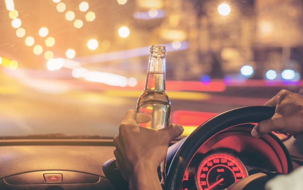 driver with open container in hand while operating the vehicle