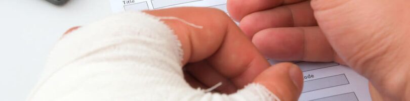 worker with cast on arm filling out a work injury form